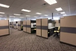 A row of empty cubicles arranged in a spacious office environment