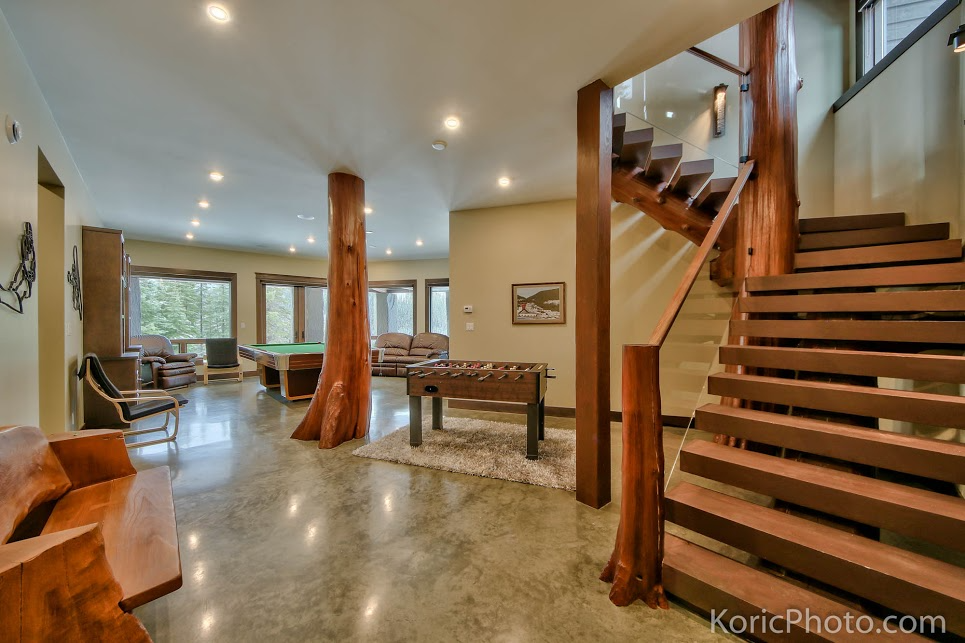 A spacious interior features wooden accents, a staircase, and ample natural light