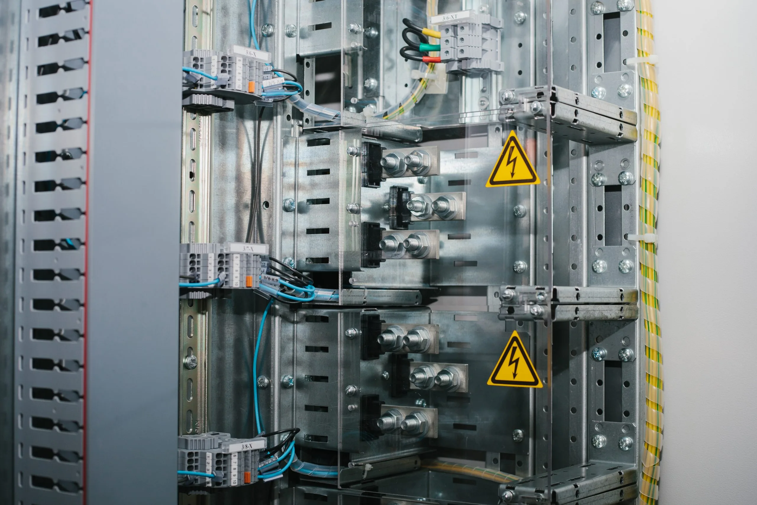 A complex electrical panel with metallic components and warning signs