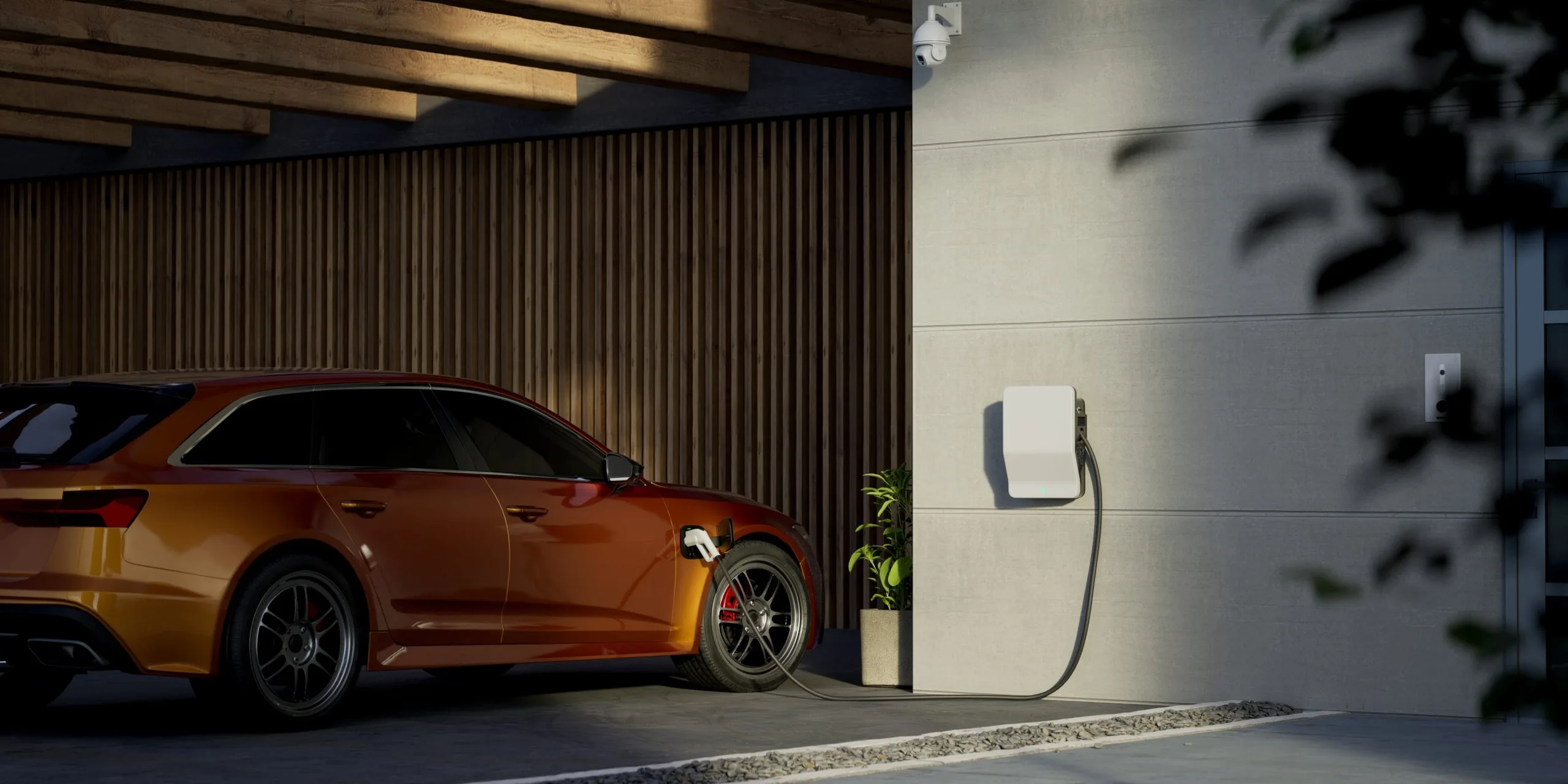 An orange car is parked beside a wall-mounted electric vehicle charger